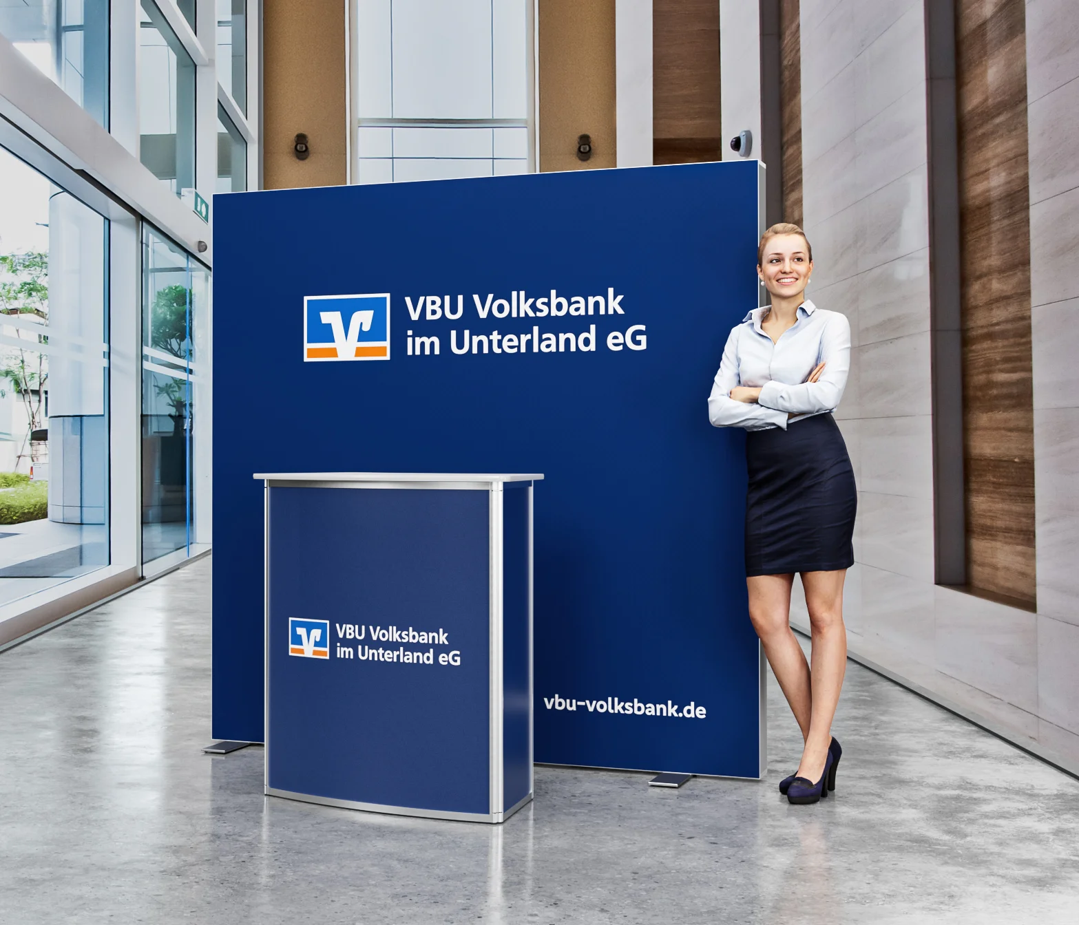 Frau vor Volksbank-Stand in Bürogebäude.